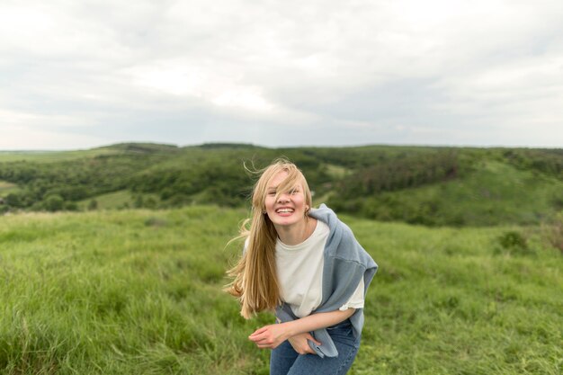 Smiley-Frau, die in der Natur aufwirft