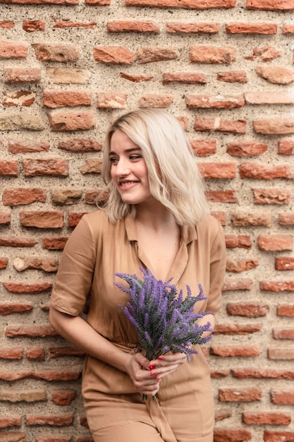Smiley-Frau, die mit Blumenstrauß des Lavendels aufwirft