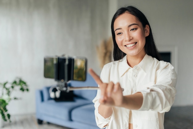 Smiley-Frau, die mit ihrem Telefon vloggt