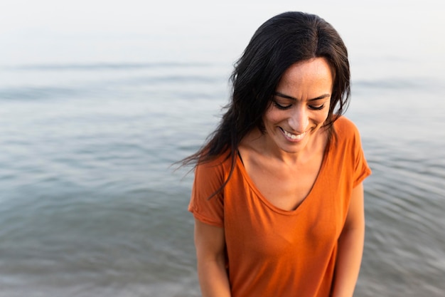 Smiley-Frau, die schön am Strand aufwirft