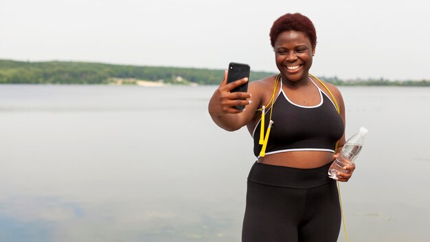 Smiley-Frau, die selfie beim Seilspringen im Freien nimmt
