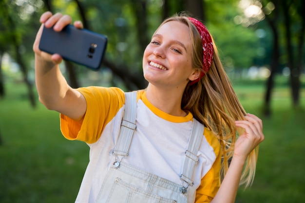 Smiley-Frau, die Selfie im Freien nimmt