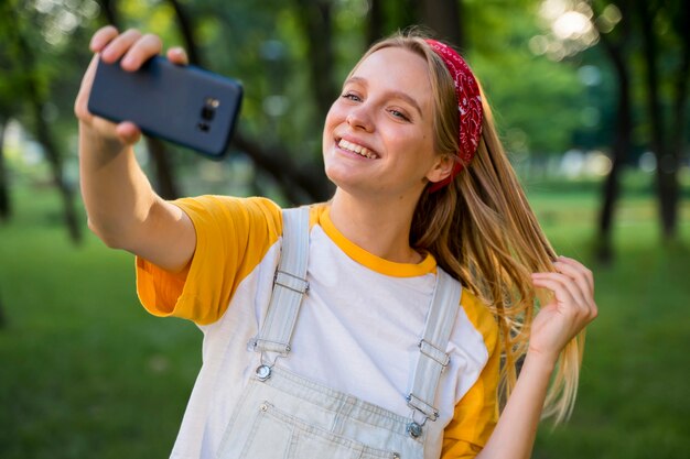 Smiley-Frau, die Selfie im Freien nimmt