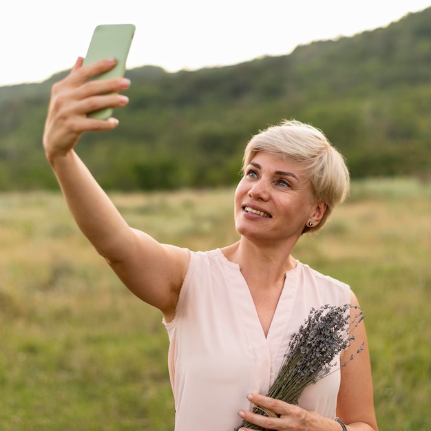 Smiley-Frau, die Selfie im Freien nimmt