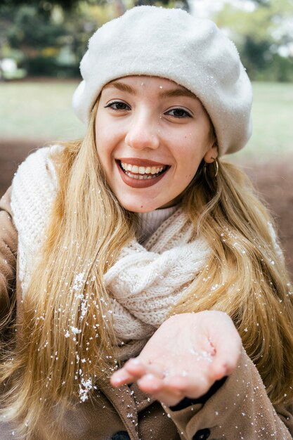 Smiley-Frau, die selfie im Park während des Winters mit Schnee nimmt