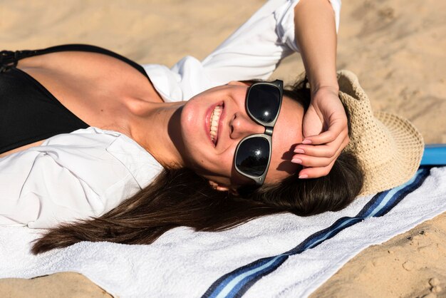 Smiley-Frau, die sich am Strand bräunt