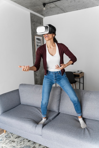 Smiley-Frau, die Spaß zu Hause mit Virtual-Reality-Headset hat