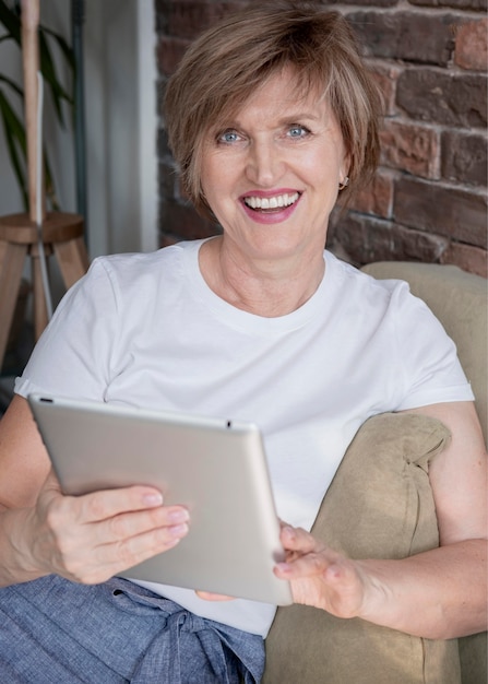 Kostenloses Foto smiley frau, die tablette mittlerer schuss hält