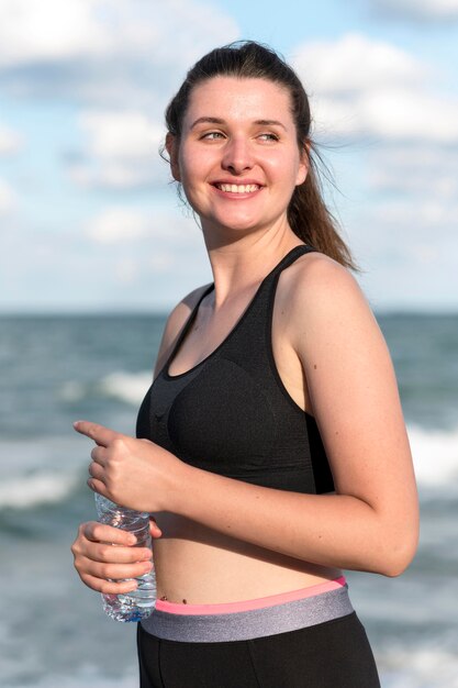 Smiley-Frau, die Wasserflasche hält