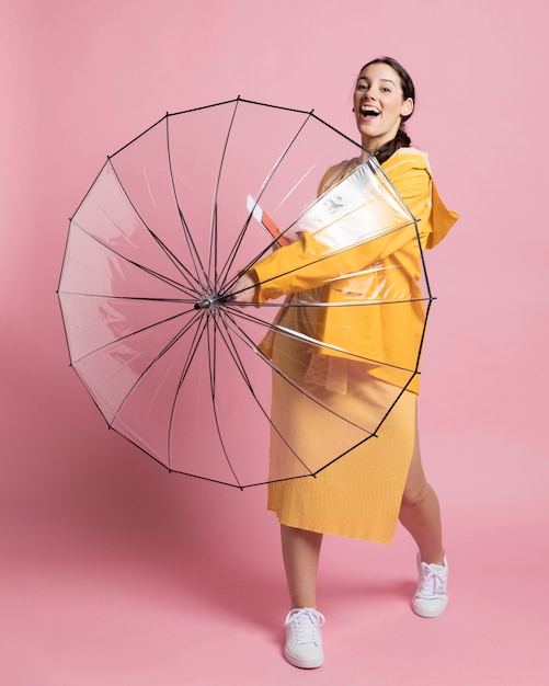 Smiley-Frau hält einen geöffneten Regenschirm