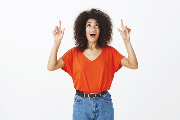 Smiley-Frau mit Afro-Frisur, die im Studio aufwirft