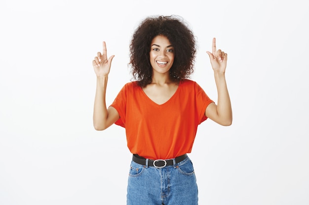 Smiley-Frau mit Afro-Frisur, die im Studio aufwirft