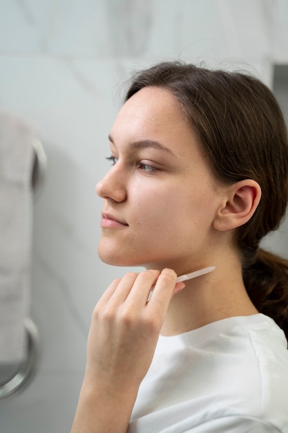 Kostenloses Foto smiley-frau mit gua-sha-tool hautnah