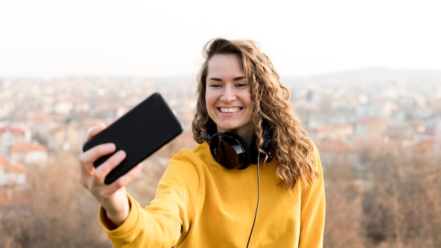 Smiley-Frau mit Kopfhörern macht ein Selfie