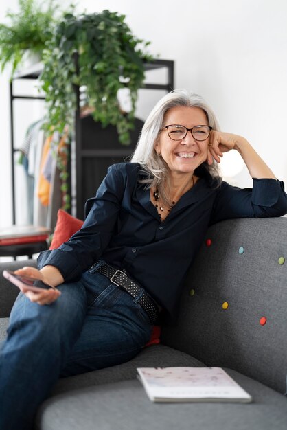 Smiley-Frau mit mittlerem Schuss auf der Couch