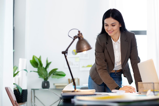 Smiley-Frau mit mittlerem Schuss bei der Arbeit