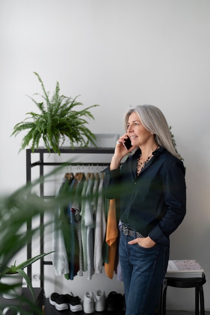 Smiley-Frau mit mittlerem Schuss, die am Telefon spricht