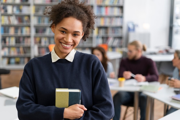 Smiley-Frau mit mittlerem Schuss, die ein Buch hält