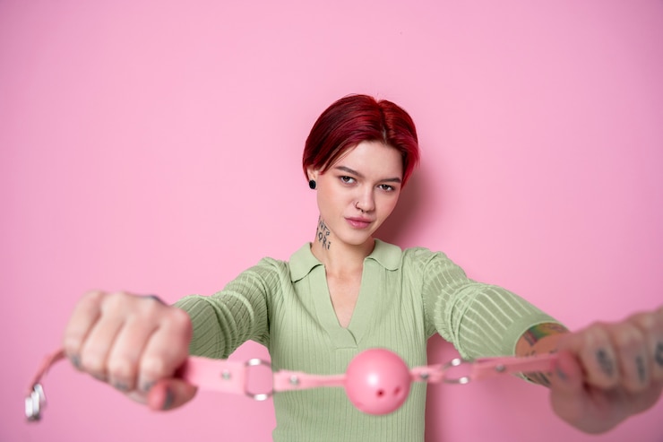 Kostenlose Foto smiley-frau mit mittlerem schuss, die einen ballknebel hält