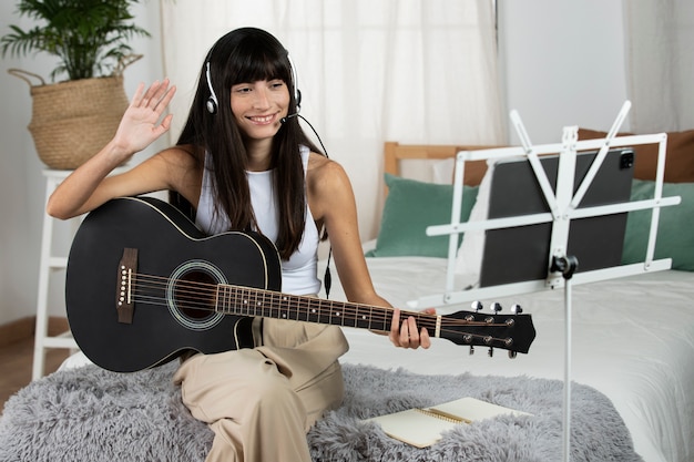 Smiley-Frau mit mittlerem Schuss, die Gitarre spielt