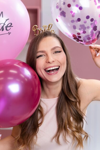 Smiley-Frau mit mittlerem Schuss, die Luftballons hält