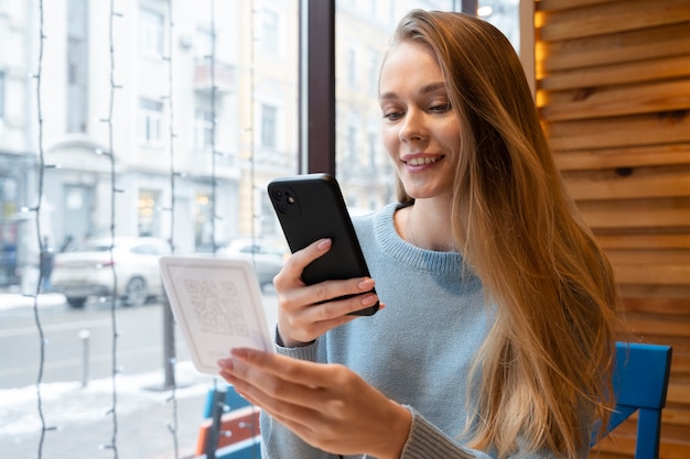 Smiley-Frau mit mittlerem Schuss, die qr scannt