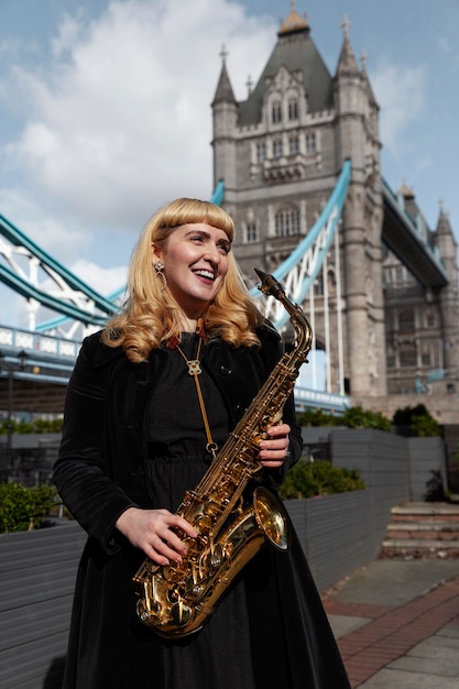 Smiley-Frau mit mittlerem Schuss, die Saxophon hält