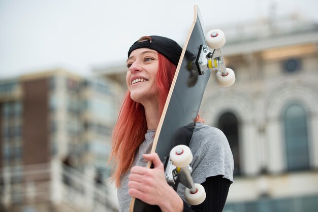 Smiley-Frau mit mittlerem Schuss, die Schlittschuh hält