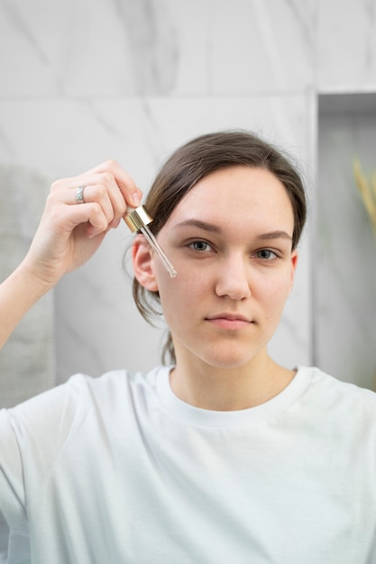 Smiley-Frau mit mittlerem Schuss, die Serum verwendet