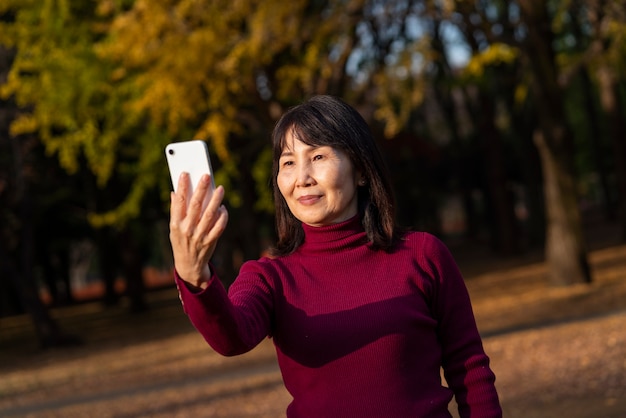 Smiley-Frau mit mittlerem Schuss, die Telefon hält