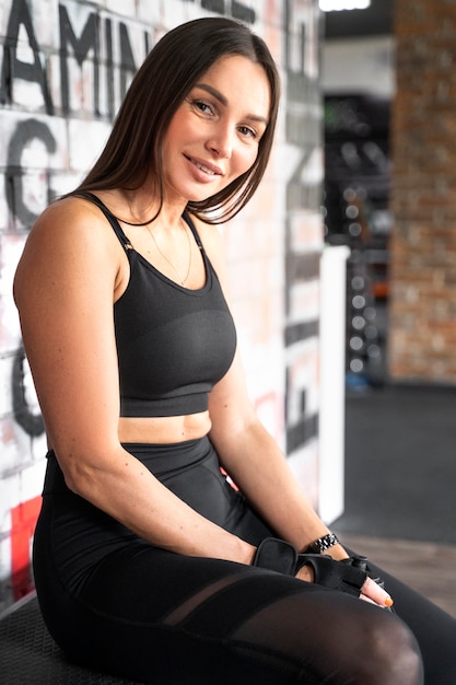 Smiley-Frau mit mittlerem Schuss im Fitnessstudio