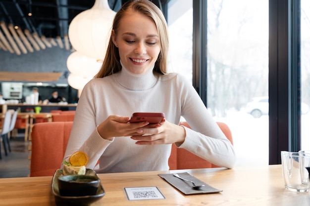 Smiley-Frau mit mittlerem Schuss im Restaurant