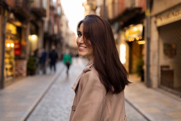 Kostenloses Foto smiley-frau mit mittlerem schuss in der stadt