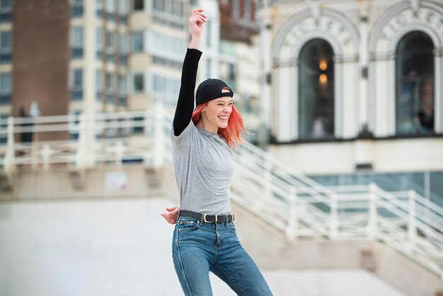 Smiley-Frau mit mittlerem Schuss in der Stadt