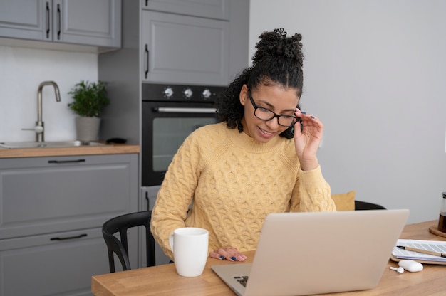 Kostenloses Foto smiley-frau mit mittlerem schuss mit laptop