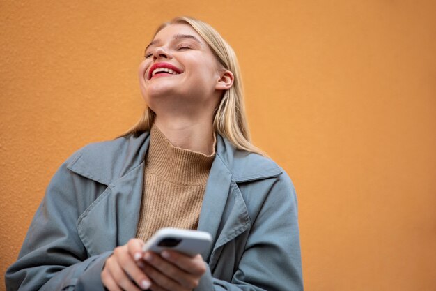 Smiley-Frau mit mittlerem Schuss mit Telefon