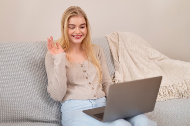 Kostenloses Foto smiley-frau mit mittlerem schuss und laptop