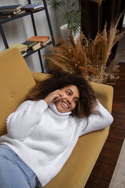 Kostenloses Foto smiley-frau mit mittlerer aufnahme auf der couch