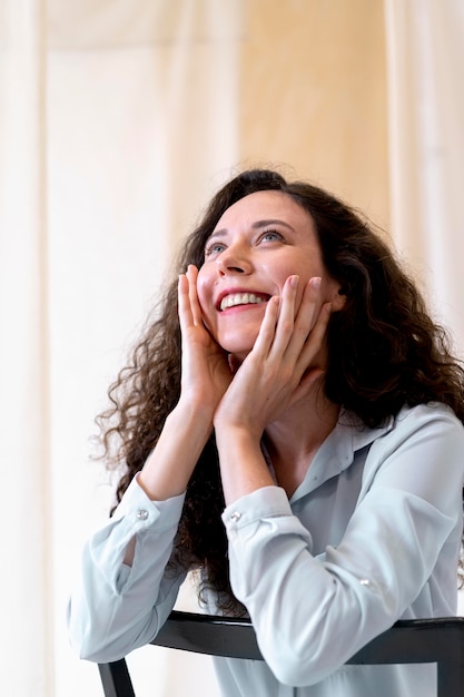 Kostenloses Foto smiley-frau mit mittlerer aufnahme auf stuhl