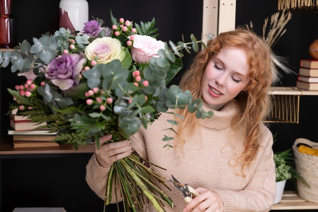 Smiley-Frau mit mittlerer Aufnahme, die Blumen hält
