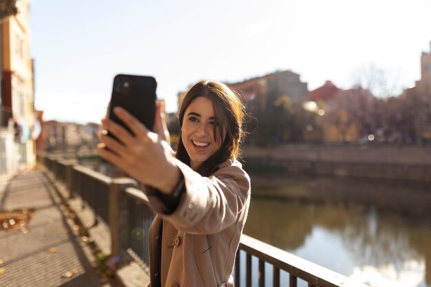 Smiley-Frau mit mittlerer Aufnahme, die ein Selfie macht