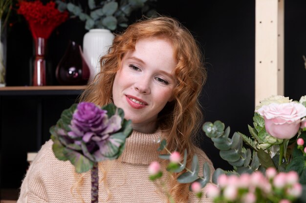 Smiley-Frau mit mittlerer Aufnahme, die eine Blume hält