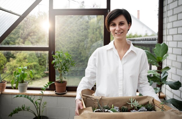 Smiley-Frau mit mittlerer Aufnahme und Topfpflanzen