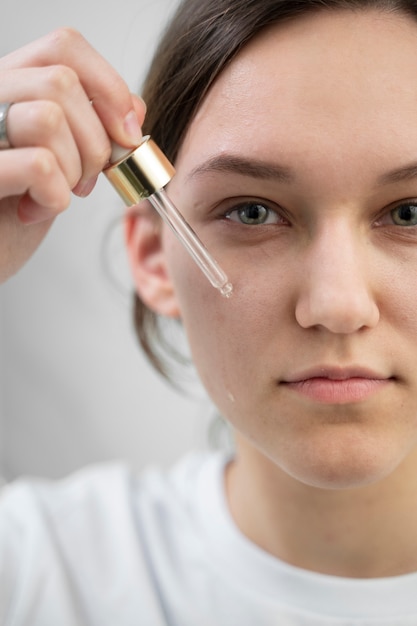 Kostenloses Foto smiley-frau mit serum hautnah