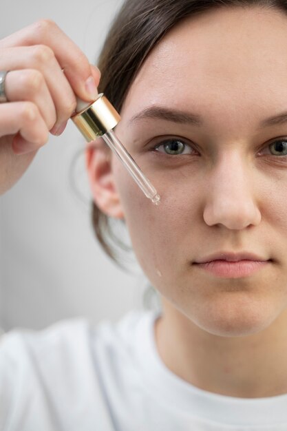 Smiley-Frau mit Serum hautnah