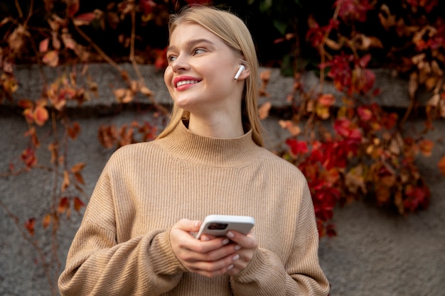 Smiley-Frau mit Telefon mittlerer Aufnahme