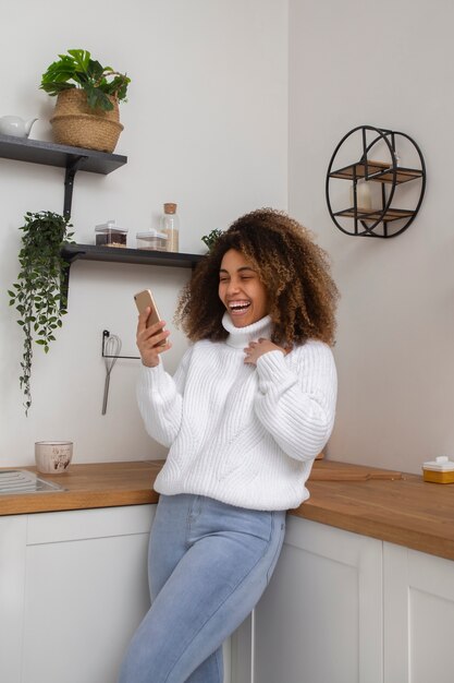 Kostenloses Foto smiley-frau mit telefon mittlerer aufnahme