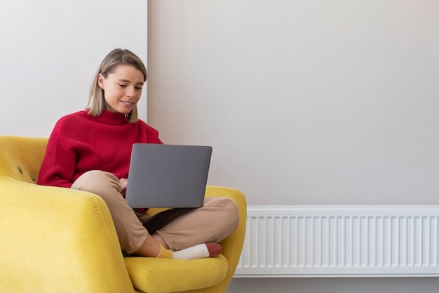 Smiley-Frau mit vollem Schuss, die am Laptop arbeitet