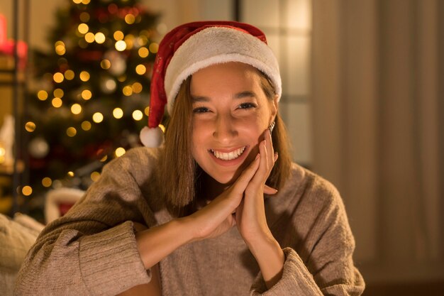 Smiley Frau mit Weihnachtsmütze posiert