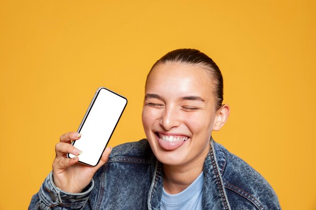 Smiley-Frau mit Zunge heraus, die Smartphone hält